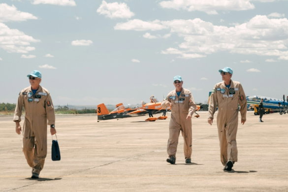 a group of men standing on top of an airport tarmac