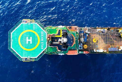 Aerial view of a large ship with helipad at sea